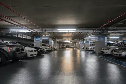 Image of an indoor parking garage filled with cars and trucks
