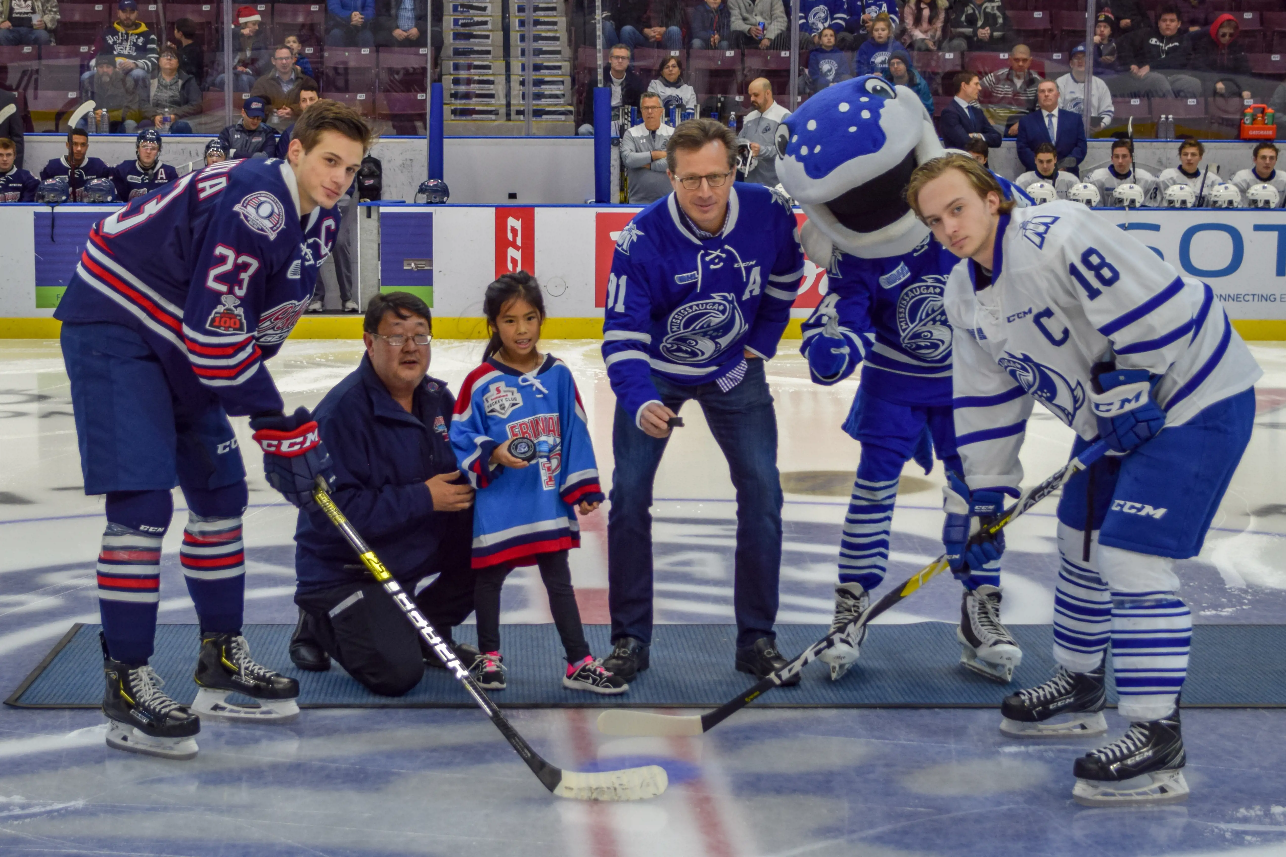 SmartStop Chairman and CEO posing with Brampton players and mascot for puck drop ceremony.