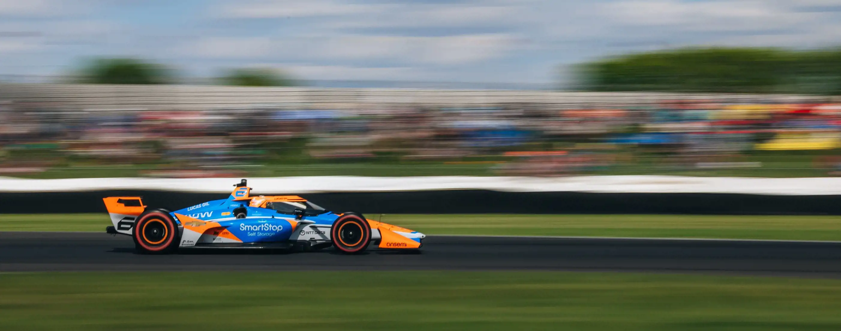 Image of Arrow McLaren #6 IndyCar racing along Indianapolis Speedway.