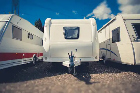 Image of three recreational vehicles parked outdoors