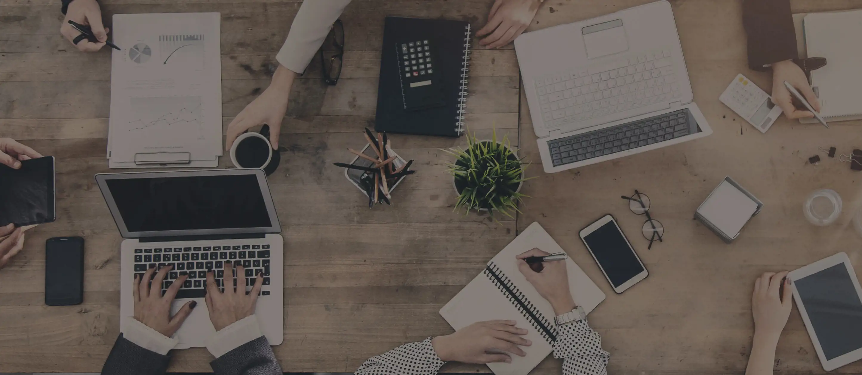Overhead image of work desk with computers, note pads, and other items for self-storage office space