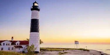 Image of lighthouse along lake at dusk