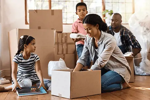 Image of family opening moving boxes inside new home or apartment